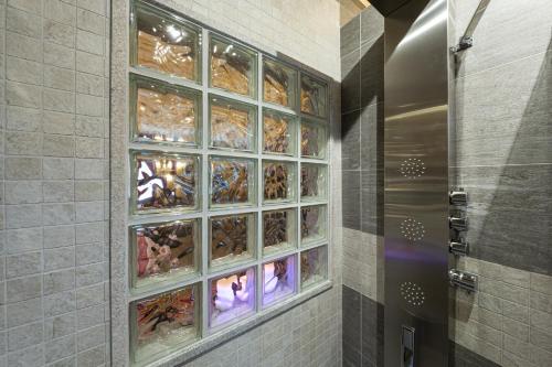 a shower with a glass block window in a bathroom at AL RANCH WELLNESS CADORE DOLOMITI APARTMENTS vicino Cortina Olimpiadi 2026 e Misurina Tre Cime Lavaredo in Pieve di Cadore