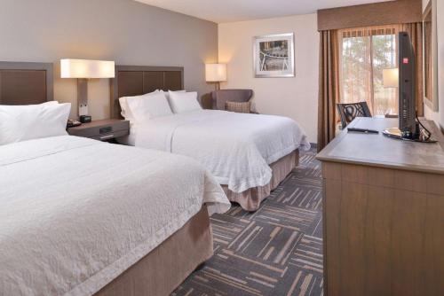 a hotel room with two beds and a television at Hampton Inn Closest to Universal Orlando in Orlando