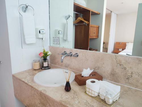 a bathroom counter with a sink and a mirror at Lombardo Suites in Mexico City