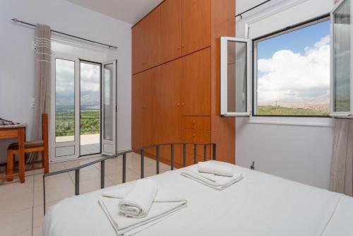 a bedroom with a bed and a large window at Kalyves Villas Collection in Áyios Andónios