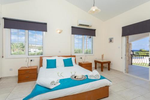 新喬里歐的住宿－Villa Thea，一间卧室配有一张带蓝色枕头的大床