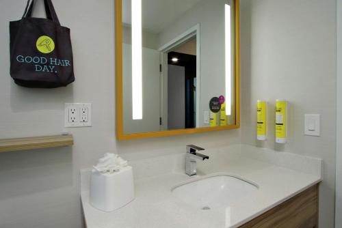 a bathroom with a sink and a large mirror at Tru By Hilton Meridian in Meridian