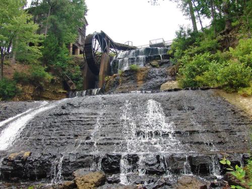 einem Wasserfall an der Seite eines Hügels mit einer Brücke in der Unterkunft Hilton Garden Inn Meridian in Meridian
