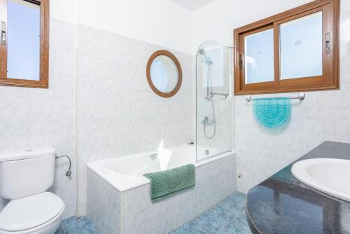 a bathroom with a toilet and a sink and a mirror at Blue Bay Villa Nicole in Mavroli
