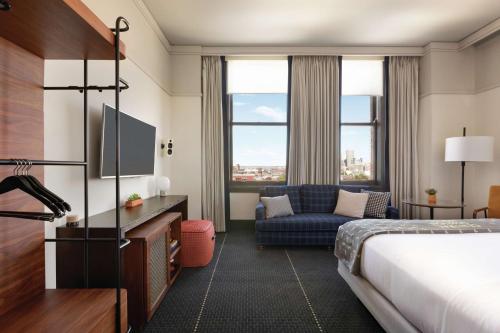 a hotel room with a bed and a couch at The Central Station Memphis, Curio Collection By Hilton in Memphis