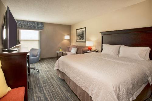 a hotel room with a large bed and a desk at Hampton Inn Memphis/Collierville in Collierville