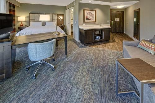 a hotel room with a bed and a desk and a couch at Hampton Inn & Suites Memphis Germantown in Memphis