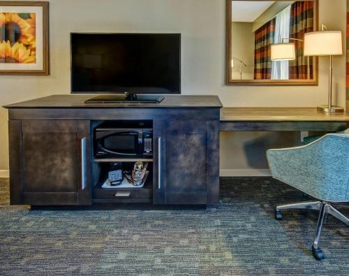 a desk with a television and a chair in a room at Hampton Inn & Suites Memphis Germantown in Memphis