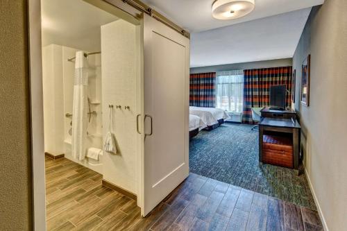 a room with a bedroom with a bed and a bathroom at Hampton Inn & Suites Memphis Germantown in Memphis