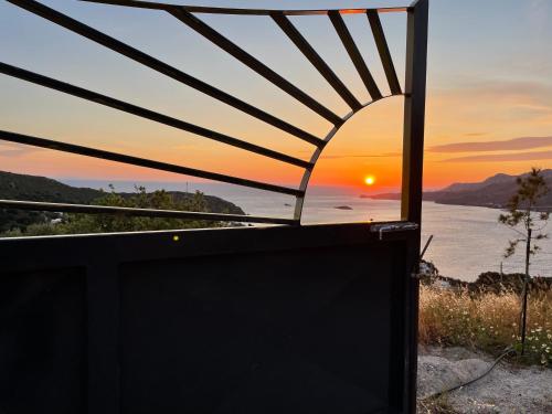 a view of the sunset from a room with a tv at VILLA NOVA Leros in Drymonas