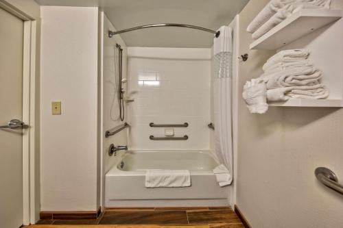 ein Bad mit einer Badewanne und einer Dusche mit Handtüchern in der Unterkunft Hampton Inn Memphis / Southaven in Southaven