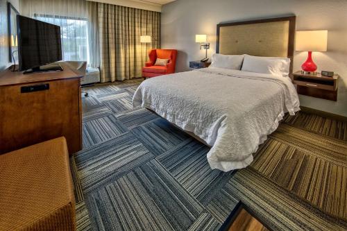 ein Hotelzimmer mit einem Bett und einem Flachbild-TV in der Unterkunft Hampton Inn Memphis / Southaven in Southaven