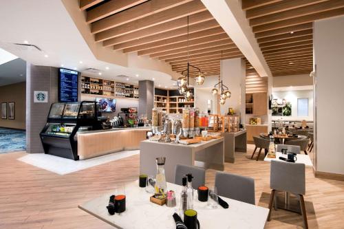 um restaurante com mesas e cadeiras e um bar em Doubletree by Hilton Phoenix Mesa em Mesa