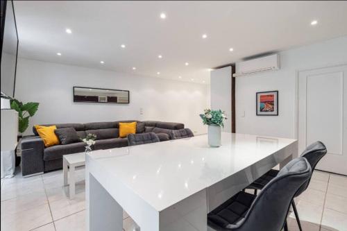 une cuisine et un salon avec une table et des chaises blanches dans l'établissement Grand appartement- Le Port A/C, à Nice