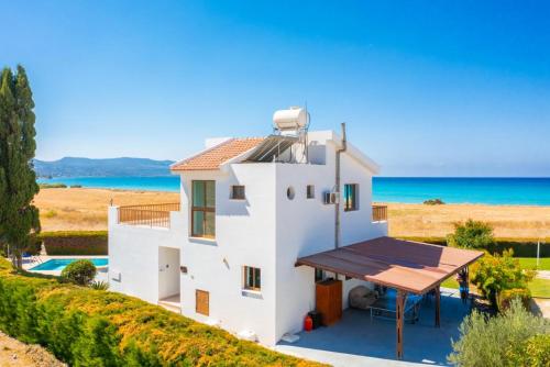 a white house with a view of the ocean at Blue Bay Villa Thea in Mavroli