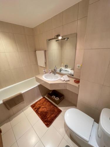 een badkamer met een wastafel, een toilet en een bad bij Cantinho da Té in Câmara de Lobos