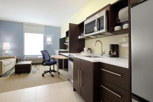 a kitchen with a sink and a living room at Home2 Suites By Hilton McAllen in McAllen