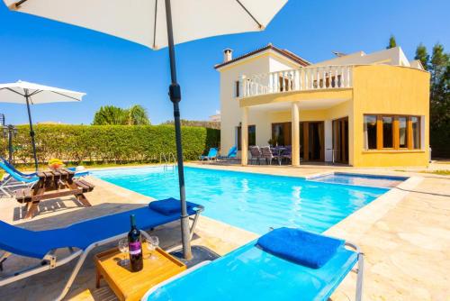 a villa with a swimming pool and a house at Villa Tsikkos Tessera in Argaka