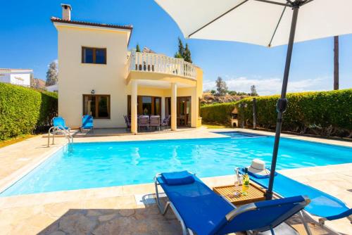 a villa with a swimming pool and a house at Villa Tsikkos Tessera in Argaka