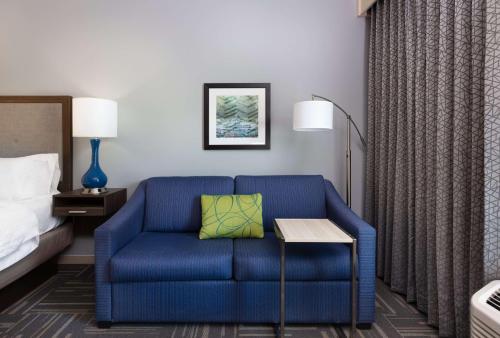 a blue chair in a hotel room with a bed at Hampton Inn Wetumpka in Wetumpka