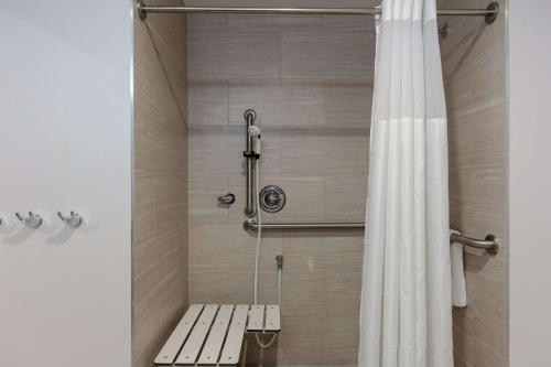 een douche met een bank naast een douchegordijn bij Hampton Inn Wetumpka in Wetumpka