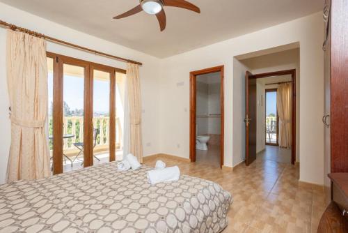 a bedroom with a bed and a ceiling fan at Villa Tsikkos Tessera in Argaka