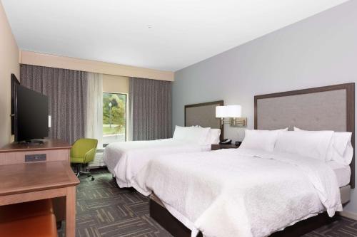 a hotel room with two beds and a flat screen tv at Hampton Inn Wetumpka in Wetumpka