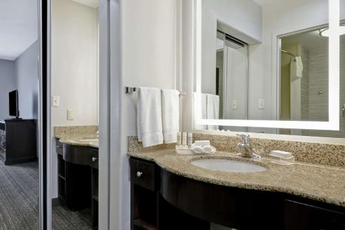 baño con lavabo y espejo grande en Homewood Suites by Hilton McAllen en McAllen