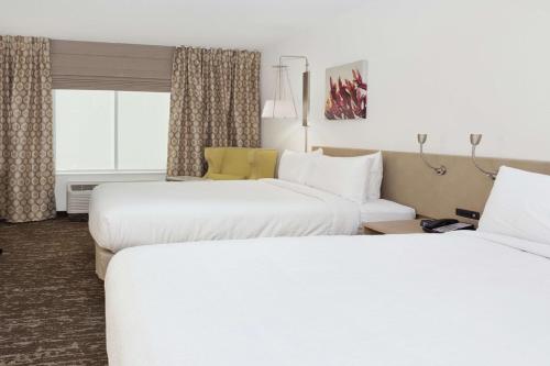 a hotel room with two beds and a window at Hilton Garden Inn Montgomery - EastChase in Montgomery