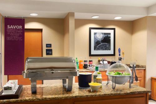 a kitchen with a counter top with a food at Hampton Inn & Suites by Hilton Manchester Bedford in Bedford