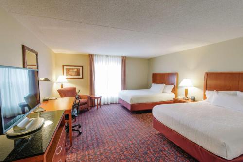 a hotel room with two beds and a flat screen tv at Hilton Garden Inn Manchester Downtown in Manchester