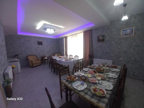 a dining room with a table with plates of food at Ninama in Mestia