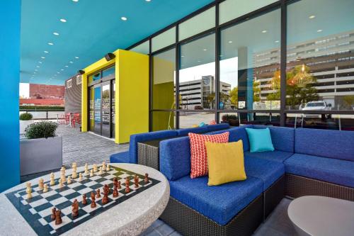 a living room with a blue couch and chessboard on a table at Tru By Hilton Manchester Downtown in Manchester