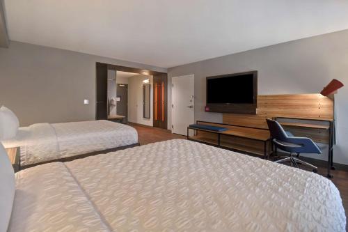 a hotel room with two beds and a flat screen tv at Tru By Hilton Manchester Downtown in Manchester