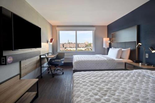 um quarto de hotel com duas camas e uma televisão de ecrã plano em Tru By Hilton Manchester Downtown em Manchester
