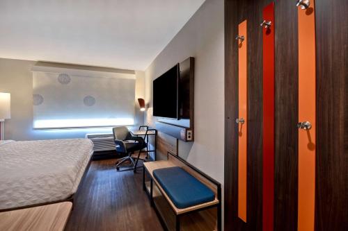 a small hotel room with a bed and a television at Tru By Hilton Manchester Downtown in Manchester