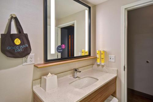 a bathroom with a sink and a large mirror at Tru By Hilton Manchester Downtown in Manchester