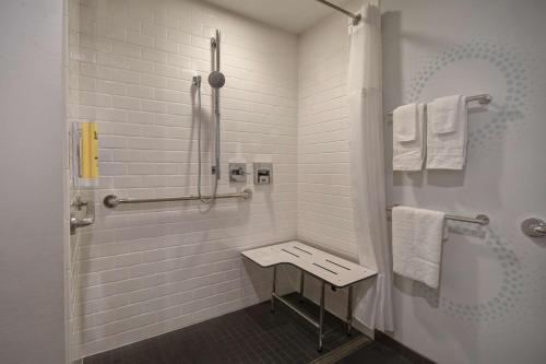 a bathroom with a shower and a bench in it at Tru By Hilton Manchester Downtown in Manchester