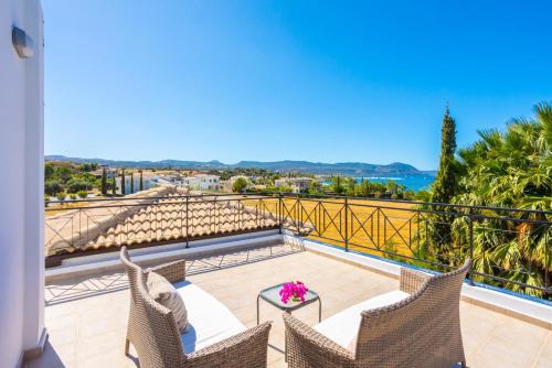 a balcony with chairs and a view of the ocean at Villa Anna in Lachi