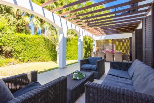 an outdoor patio with wicker furniture and a pergola at Villa Anna in Lachi