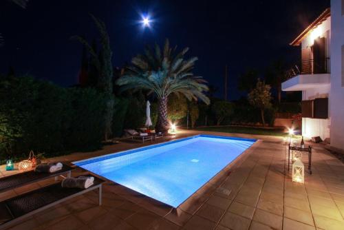 a swimming pool in a backyard at night at Villa Anna in Lachi