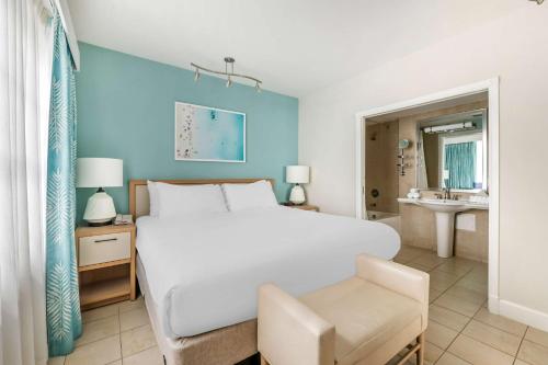 a bedroom with a large white bed and a bathroom at Hilton Vacation Club Crescent on South Beach Miami in Miami Beach
