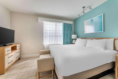 a bedroom with a large bed and a television at Hilton Vacation Club Crescent on South Beach Miami in Miami Beach