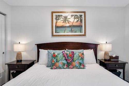 a bedroom with a bed with two night stands and two lamps at Kauai Kailani Resort #109 in Kapaa