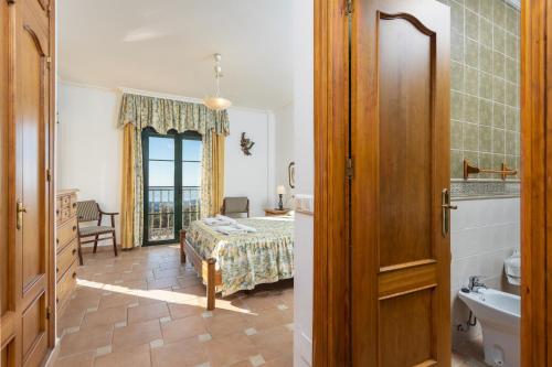 1 Schlafzimmer mit einem Bett und einem Bad in der Unterkunft Villa El Pedregal in Frigiliana