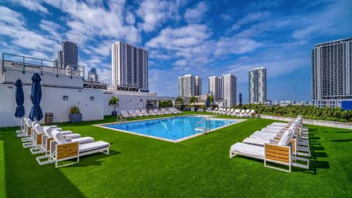 a pool with white lounge chairs and a resort at Hilton Miami Downtown in Miami