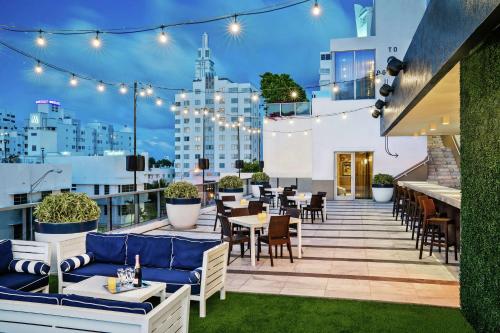 a rooftop patio with tables and chairs and lights at Gale South Beach, Curio Collection By Hilton in Miami Beach