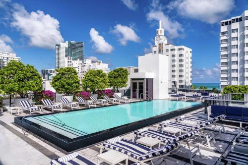 una piscina en la azotea de un edificio con tumbonas en Gale South Beach, Curio Collection By Hilton, en Miami Beach
