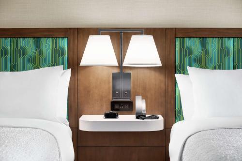 a hotel room with two beds and a nightstand between them at Hampton Inn & Suites Miami, Kendall, Executive Airport in Kendall