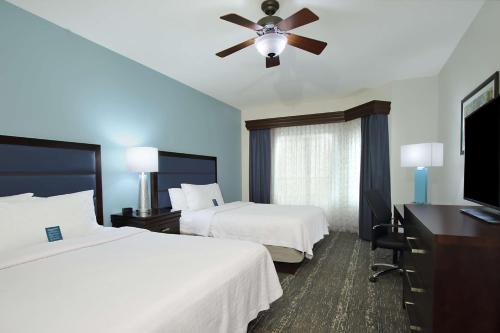 a hotel room with two beds and a ceiling fan at Homewood Suites by Hilton Miami - Airport West in Miami